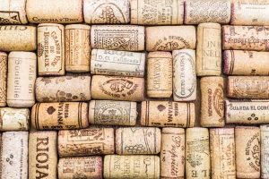 Numerous wine corks are artistically laid out showing which vineyards they originated